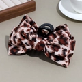 Dettaglio molletta per capelli con fiocco leopardato e strass argentati su sfondo elegante - Rosso Scuro Leopardato con Strass