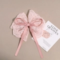 Close-up of pink floral lace bow hair clip with detailed mesh embroidery and satin ribbon - Pink