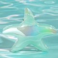 Dettaglio macro della pinza per capelli a stella marina iridescente con finitura perlata - Teal Trasparente