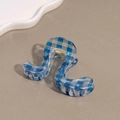 Macro view of blue plaid wavy claw clip with transparent texture and gold spring - Blue Wave