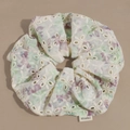 Detailopname van witte eyelet kant scrunchie met bloemenborduurwerk en merklabel - Paars
