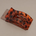 Detail view of the tortoiseshell flat hair claw clip with amber resin texture and rounded teeth - Glossy Red Leopard