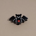 Detalle de pinza de pelo negra de murciélago con corazón rojo para Halloween - Estampado de Murciélago de Corazón