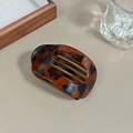 Flat amber leopard print hair claw clip in a minimalist wooden tray setting - Leopard Print