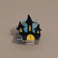 Dettaglio molletta per capelli di Halloween con castello stregato nero e lapide RIP - Castello Blu Nero