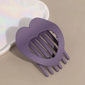 Macro shot of matte purple heart-shaped hollow hair claw clip with rounded teeth texture - Purple