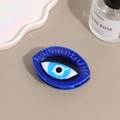Detail of blue evil eye hair claw clip with acetate marble texture on neutral background - Blue Evil Eye