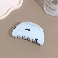 Detail of light blue striped hair claw clip with black bow patterns on a flat surface - Semicircle Bowknot