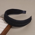 Detalle de diadema de punto negro con textura trenzada sobre un fondo neutro elegante - Textura Lisa / Negro