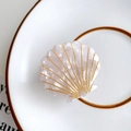 Elegante pinza de pelo con forma de concha blanca y detalles dorados en plato - Blanco concha