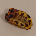 Close-up of tortoise shell pattern hair claw clip with a curved ergonomic design - Yellow Leopard