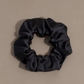 Close-up detail of smooth black satin fabric texture on a large elastic hair scrunchie - Scrunchie / Black