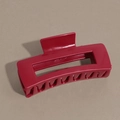 Vue macro d'une pince à cheveux rectangulaire rouge au design géométrique creux et fini mat - Rouge