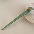 Detailed close-up of marble pattern acetate hair pin with Creation France engraving - Green