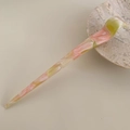 Detailed macro view of acetate hair stick with pink marble texture and France engraving - Pink