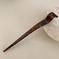 Detail showing tortoise shell hair stick with silver Creation France text on beige marble - Blue Brown