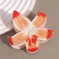 Detailed macro view of an elegant white and orange lily flower hair claw with gradient petals - Orange