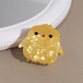 Gros plan d'une pince à cheveux poussin jaune mignonne en acétate texturé élégant - Poussin jaune
