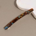 Detailansicht der Acetat-Haarspange mit Schildpattmuster und goldenem Logo-Schriftzug - Crushed Ice Bernstein