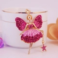 Gouden engel sleutelhanger met roze strass-steentjes hangend aan een witte mok - Lichtroze