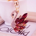 Elegant gold-tone swan keychain with red crystals and white rhinestones on bag charm - Purple