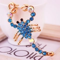 Portachiavi con ciondolo a scorpione dorato con strass blu scintillanti su una tazza - Blu