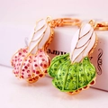 Creative rhinestone-studded peanut shaped keychain set in pink and green enamel - Random Color