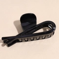 Dettaglio dell'elegante pinza per capelli nera lucida con design aerodinamico - Nero Lucido