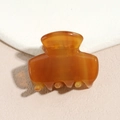 Detailed view of translucent amber resin hair claw with smooth finish and inner spring - Brown