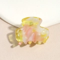Detailed close-up of marble pattern acetate hair claw clip with golden metal spring - Pink Yellow Gradient