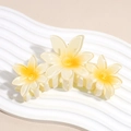 Dettaglio di un grande fermaglio per capelli con tre fiori di plumeria gialli sfumati - Giallo
