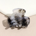Macro detail of acetate shark hair claw showing elegant black and white marble texture - Ink Black and White