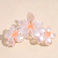 Detailansicht der eleganten, perlmuttrosa Haarklammer mit Plumeria-Blütendesign - Orange