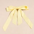 Detail einer hellgelben Satin-Schleifen-Haarspange mit langen fließenden Bändern - Gelb