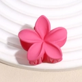 Gros plan d'une pince à cheveux fleur rose mat au design plumeria avec dents robustes - Forme de Fleur / Rose Rouge Dépoli