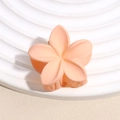 Dettaglio della molletta per capelli a fiore opaco color pesca su un supporto bianco - Forma di Fiore / Arancione Opaco