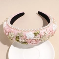 Detail of pink embroidered floral headband with white pearls on a ceramic dish - Pink