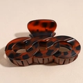 Dettaglio del grande fermaglio per capelli in ambra tartarugata con design ad anelli intrecciati - Leopardo Rosso