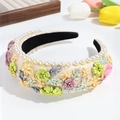 Close-up of pearl embellished floral embroidery on premium padded satin headband - Yellow