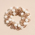 Detailed macro view of elastic hair tie with white pearls and champagne crystal beads - Brown
