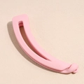 Gros plan d'une pince banane rose mat pour femmes sur un fond beige texturé élégant - Rose