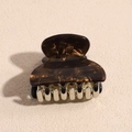 Detail van de kleine vierkante haarklem met schildpadpatroon en zilveren metalen tanden - koffiekleur