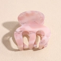Detailed macro view of small pink marble acetate claw clip with smooth curved teeth - Pink