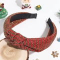 Detail eines rot-grünen Glitzer-Stirnbands mit Knoten auf festlichem Holz - Knoten-Stil / Geknotetes Rot