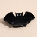 Macro shot of Halloween hair claw featuring a black glitter bat design with cartoon eyes - Black Bat