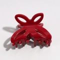 Detail view of a bright red butterfly hair claw clip with cutout design on white backdrop - Red