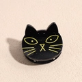 Close-up of a black cat hair clip with silver glitter and yellow facial details - Black Cat