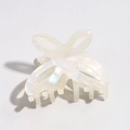 Detailed macro view of pearlescent white butterfly hair claw with hollow wing design - White