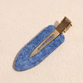 Détail d'une barrette à motif denim bleu avec pince élégante en métal doré brillant - Bleu Goutte d'eau