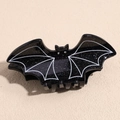 Close-up of black glitter bat hair claw with white wing details and rhinestone eyes - Spider Web Bat